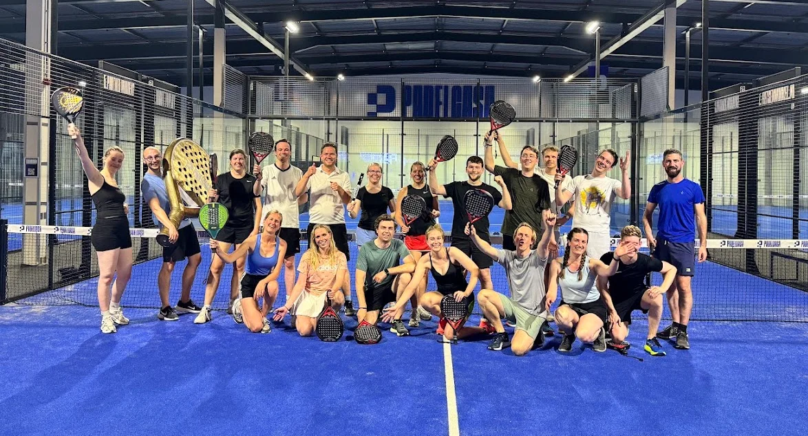 Groepsfoto na een sportieve activiteit op de padelbaan